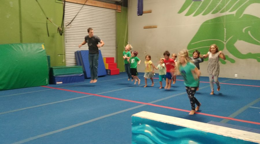 Preschool age students warm up in a parkour class