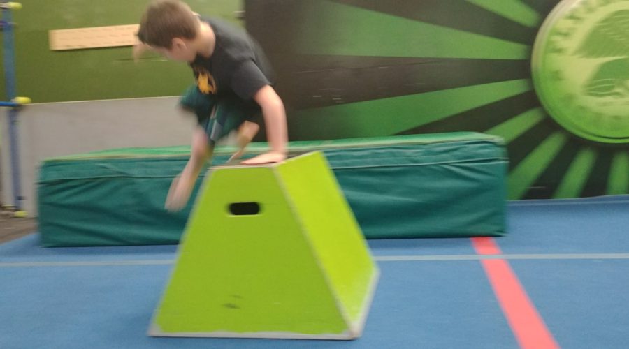 A Flying Frog student vaulting over a block in the gym